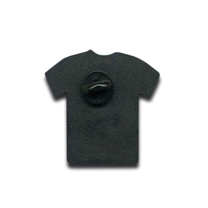 A black, T-shirt-shaped enamel pin by Bayside, inspired by the Errors Tour Pin, is shown from the back with a central butterfly clutch attachment, set against a white background.