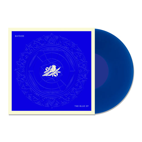 A transparent blue vinyl record slides out of a deep blue, white-bordered cover featuring a white rose and intricate circles. Text on the square sleeve reads 