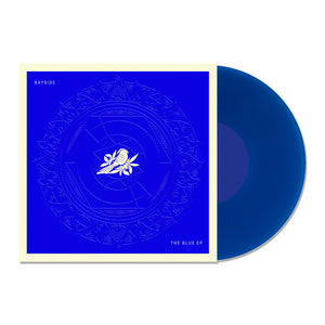 A transparent blue vinyl record slides out of a deep blue, white-bordered cover featuring a white rose and intricate circles. Text on the square sleeve reads "Bayside" and "Blue EP." Brand: Bayside.