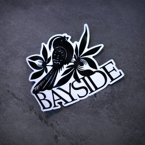 image of a sticker that is a bird and says bayside. laid flat on a concrete floor