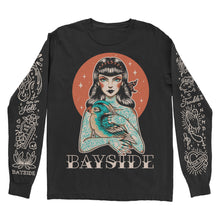 Load image into Gallery viewer, image of a black long sleeve tee shirt on a white background. tee has full body print of a girl with tattoos all over holding a bird. across the bottom says Bayside. each sleeve has tattoo flash art