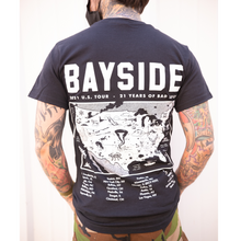 Load image into Gallery viewer, image of a man with white background from the next down with tattoos on his neck and both arms that are in his pockets. facing away showing the back of a black t shirt with a full back print in white. the top of the t shirt says bayside at the top, 21 U S tour, 21 years of bad luck with a map of the USA and tour dates on the bottom