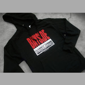 image of the front of a black pullover hoodie on a concrete background. hoodie has a red print that says bayside. below is a black and white rectangle image of a bird on water.